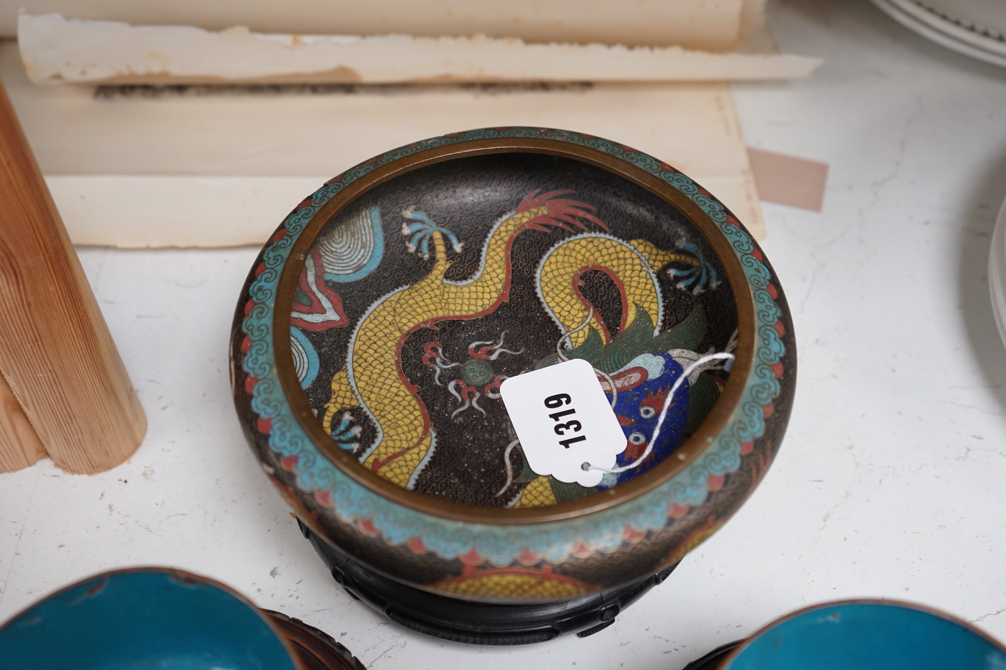 A Chinese cloisonné enamel 'dragon' bowl, six Chinese floral cloisonné enamel bowls and four Canton enamel dishes and wood stands